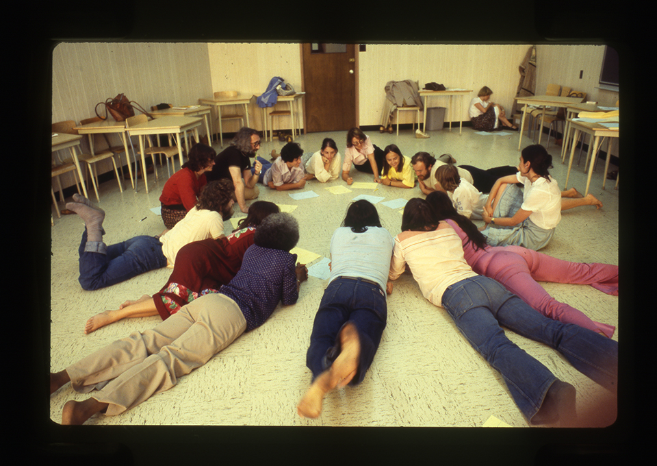 Des participants au 7e congrès d’expression dramatique sont couchés par terre en cercle, 1978. / Photographe inconnu. 1 photographie : diapositive coul. Archives UdeM, P0419-K-3-D0006