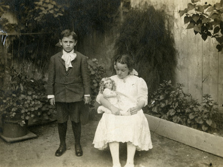 Photographie montrant Auguste Descarries et de sa soeur Marie Rose dans la cour de la maison familiale.
